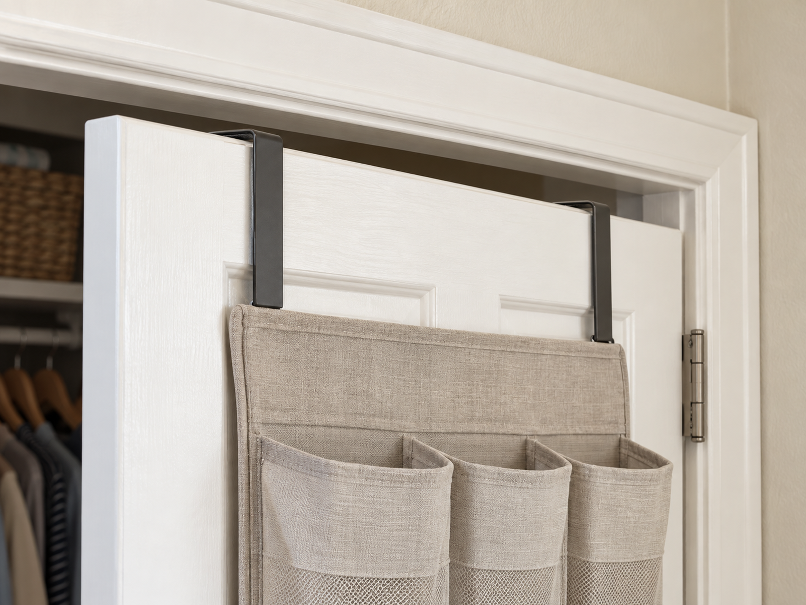 Two flat over-door brackets sit on a closet door with visible clearance beneath the top frame so the door can close without rubbing.